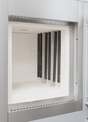 Vertically mounted SiC rods and optional perforated air inlet tubes of the debinding system in a high-temperature furnace